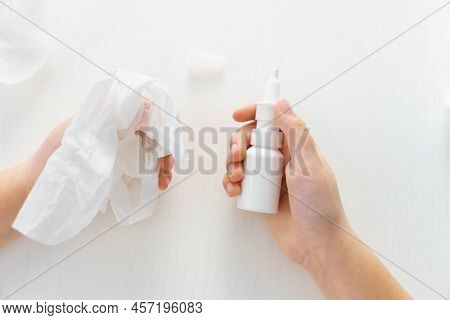 Female Child Hands Hold Medicine Bottle Nose Spray An Napkin On White Background With Used Paper Tis