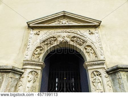 Zhovkva, Ukraine. The Entrance To The St. Lawrence Church. Ancient Aged Carved Gates. Ornate Arched 