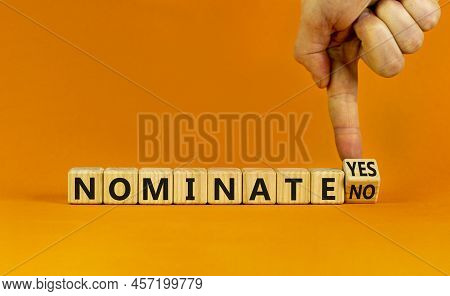 Nominate Symbol. Businessman Turns A Wooden Cube And Change Words 'nominate No' To 'nominate Yes'. B