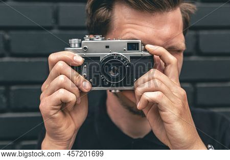 A Young Man Takes A Photo With A Vintage Film Camera.
