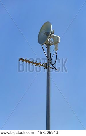 Vhf, Uhf, Microwave Antennas On Pole Against Blue Sky.