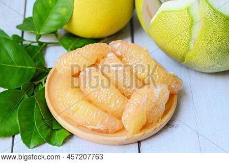 Pomelo Fruit On Wooden Plate  Background, Fresh Green Pomelo Peeled And Leaf Frome Pomelo Tree , Pum