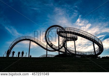 Photographers With Tripods As Silhouettes At The Walkable Roller Coaster Sculpture Tiger And Turtle 