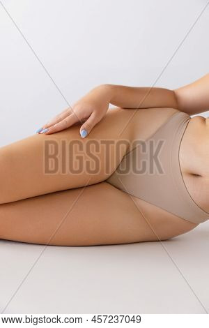 Cropped Image Of Female Body, Legs Isolated Over Grey Studio Background. Model In Shapewear Underwea