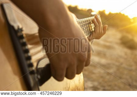 Guitar And Sunset. Playing Acoustic Guitar During Sunset. Playing Music During Sunset. Enjoying The 