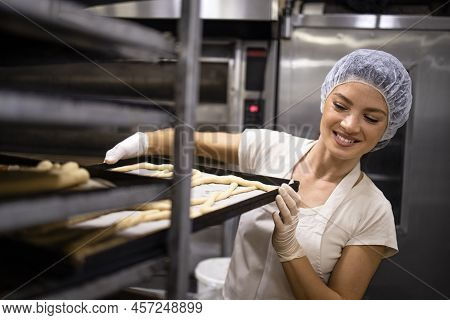 Working In Bakery Food Production Preparing Raw Bread And Pastry For Baking.