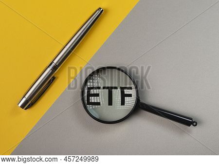 Etf Analysis Concept. Word Through Magnifying Glass. High Quality Photo
