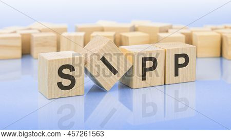 Four Wooden Blocks With The Letters Sipp - On The Bright Surface Of A Blue Table. The Inscription On