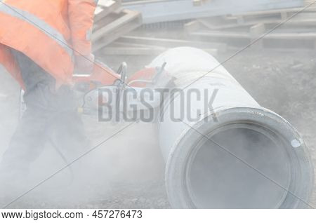 A Worker At The Construction Site Cutting A Concrete Drainage Pipe With A Concrete Saw.
Builder Cove