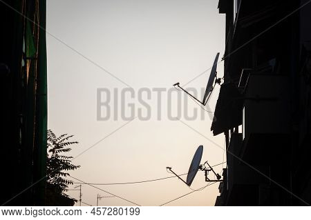 Shapes And Shadows Of Satellite Dish And  And Tv Uhf Antennas On Display At The Top Of A Residential