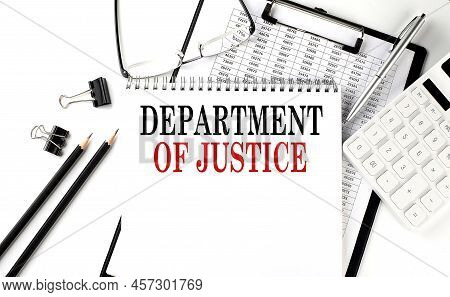 Doj - Department Of Justice Word On A Notepad With Clipboard , Chart And Calculator, Business Concep