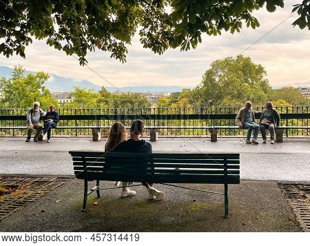 Geneva, Switzerland - September 15 2021: A Romantic View Of A Young Couple Sitting On A Park Bench I