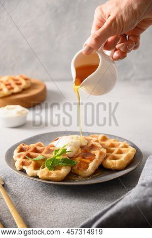 Woman Pouring Syrup Croffles For Tasty Breakfast.
