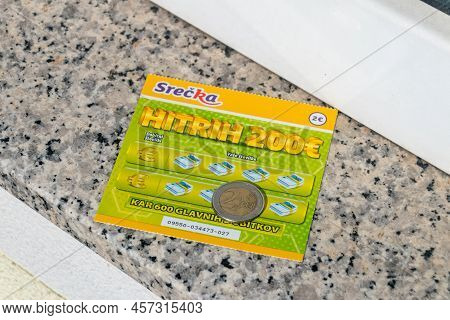 Maribor, Slovenia - June 2, 2022: Slovenian Lottery Scratch Card And 2 Euro Coin.