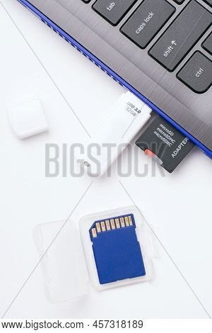 Microsd Memory Card With Adapter, White Usb Stick Plugged In The Ports Of The Modern Blue Laptop. On