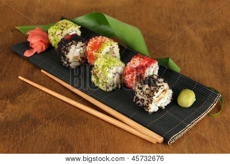 Velsmagende Maki sushi - Roll på måtten på brune baggrund