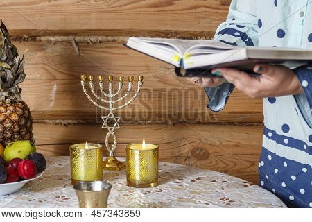 A Jewish Woman, After Lighting Candles, Reads The Evening Prayer Of Maariv According To The Siddur. 