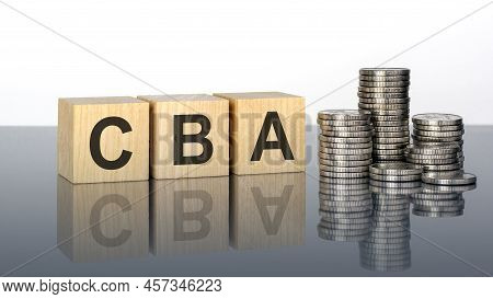 Cba. Wooden Cubes. Blocks Lie On A Black Background. Stacks With Coins. Inscription On The Cubes Is 