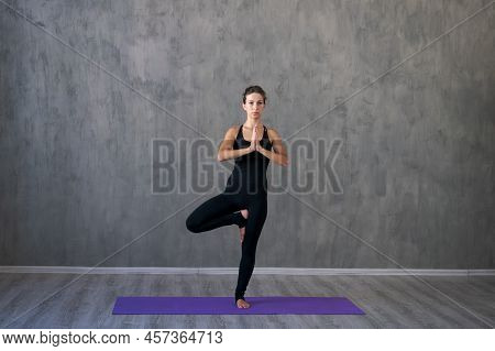 Athletic Young Woman Doing Yoga Isolated On Gray Wall Background In Black Sportswear Concept Of Heal