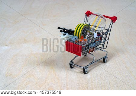 A Shopping Cart With Electrical Parts And Components. Terminals, Light Bulb, Electrical Tape, Cable 