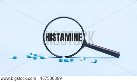 On A Blue Background, White And Blue Capsules With Pills And A Black Magnifying Glass With The Text 