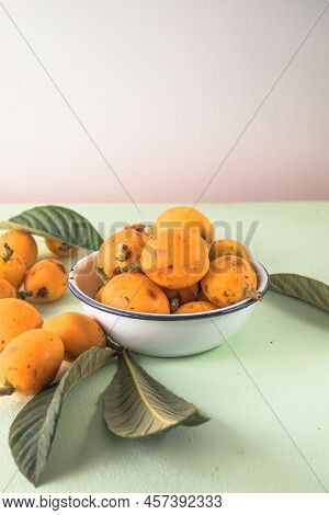 Ripe Medlar Fruit , Eriobotrya Japonica, And Green Medlar Leaves On Wooden Table. Top View