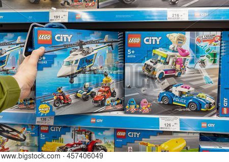 Lego Constructor In A Customer's Hand. A Customer Takes A Box Of Lego From A Shelf In A Store. Minsk