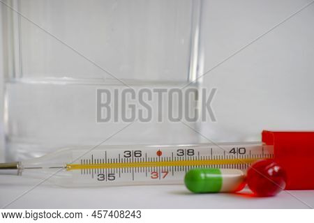 Thermometer, Pills On A Light Background Pharmacy