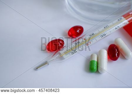 Thermometer, Pills On A Light Background Pharmacy