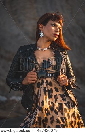 Summer Street Style On A Beach Next To Rocks Of A Young Brunette Caucasian Woman In A Leopard Dress 