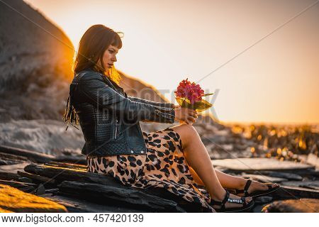 Summer Street Style On A Beach Next To Rocks Of A Young Brunette Caucasian Woman In A Leopard Dress 