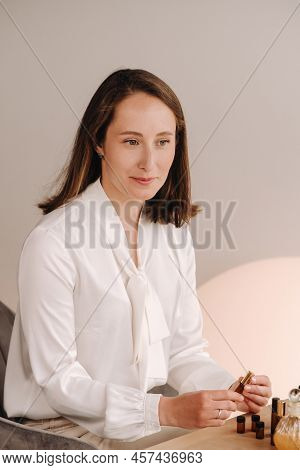 The Aromatherapist Girl Is Sitting In Her Office. There Are Essential Oils On The Table