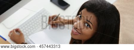 Top View Of Smiling Latin Woman On Workplace, Open Empty Journal, Modern Luxury Devices On Desk. Fir