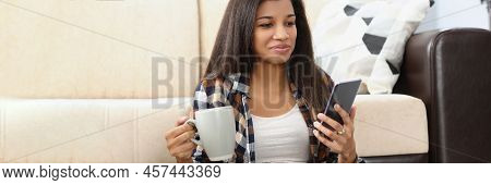 Portrait Of Latino American Woman Using Smartphone And Laptop For Spare Time. Enjoying Weekend At Ho