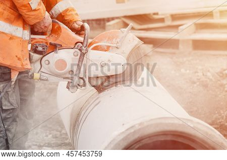 A Worker At The Construction Site Cutting A Concrete Drainage Pipe With A Concrete Saw.
Builder Cove