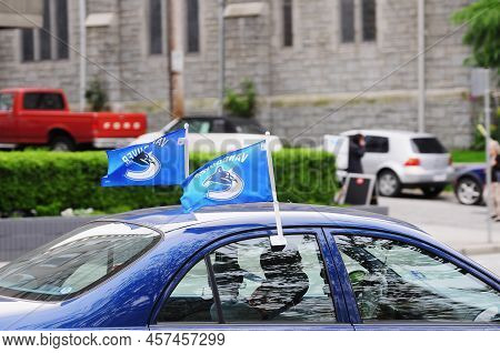 Vancouver Canucks Professional Ice Hockey Team Flags On The Top Of The Car.