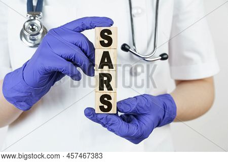Medicine And Health Concept. The Doctor Holds Cubes In His Hands On Which It Is Written - Sars. Atyp