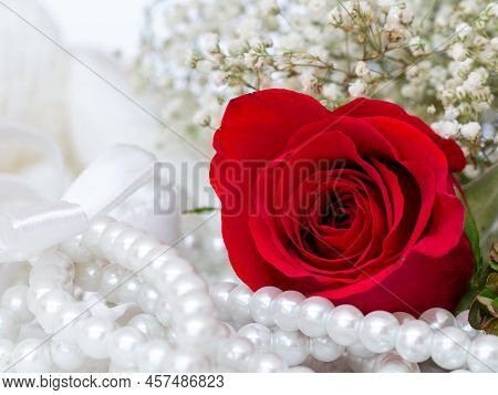Close Up Of Red Rose On White Lace And Pearls Dedorated Around.