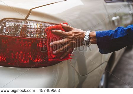 Man's Hand Cleaning Car & Drying Vehicle With Microfiber Cloth. Hand Wipe Down Paint Surface Of Shin