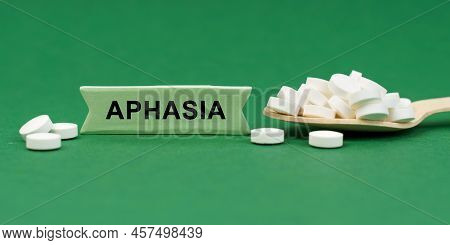 Medicine Concept. On A Green Surface, A Wooden Spoon With Pills And A Sign With The Inscription - Ap