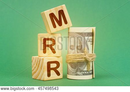 Business Concept. On A Green Surface, Dollars And Cubes With The Inscription - Mrr