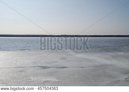 A Wide River Is Being Freed From Ice. Spring Day Light Blue Sky, River Flood With Blue Water. At The