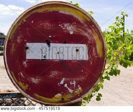 Weathered, Scratched And Dirty Old Red And White Round No Entry Road Sign With Muddy Road Leading