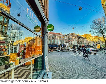The Hague, Netherlands - December 16 2021 : Cyclists Are Passing By The Store Front Of A Tex Mex Res