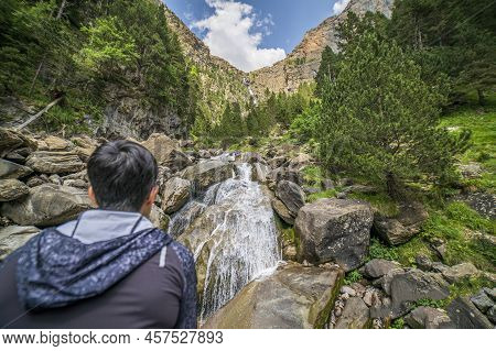 Female Hiker Observing The Cotatuero Waterfall And River In The Ordesa And Monte Perdido National Pa