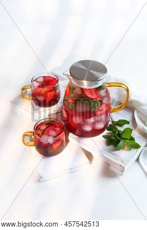 Strawberry Lemonade In A Jug And Two Glass Glasses. Summer Drinks Season. Strawberries With Mint And