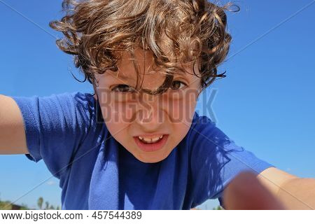 Selective Focus To Excited Emotion Face Of Arabian Preschooler Boy With Big Hazel Eyes On Blurred Bl