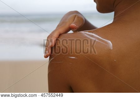 Closeup Woman Applying Sunblock Cream Lotion On Beach For Broad Spectrum Uva, Uvb Sun Protection