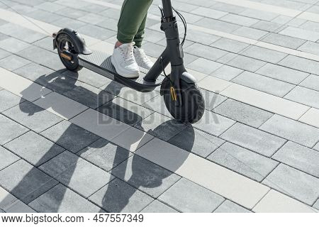 Woman In White Sneakers Standing On Electric Scooter