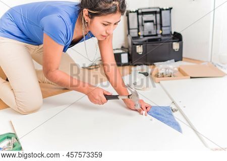 Latin Bolivian Strong And Independent Success Woman Assembly And Repair Furniture With Hammer.